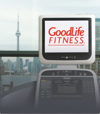 Cardio machine with the GoodLife Fitness logo on the screen and the CN tower in the background 